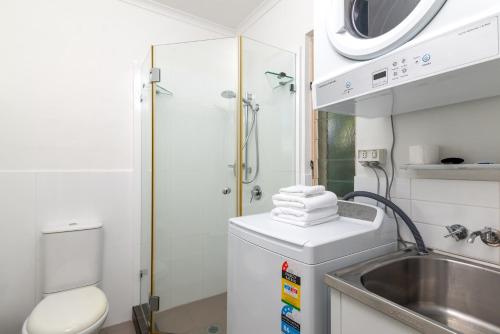 een kleine badkamer met een wastafel en een toilet bij Seascape Holidays at Reef Terraces on St Crispins in Port Douglas
