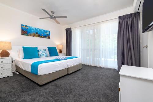 een slaapkamer met een bed en een groot raam bij Seascape Holidays at Reef Terraces on St Crispins in Port Douglas