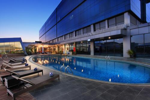 a large swimming pool in front of a building at Swiss-Belhotel Cirebon in Cirebon