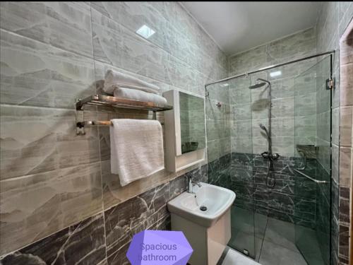 a bathroom with a glass shower and a toilet at Spacious and Serene 1 bedroom apartments with a lake view and town view in Nakuru
