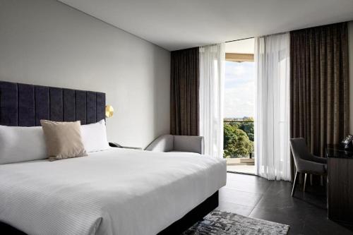 a bedroom with a large bed and a large window at Crowne Plaza Sydney Burwood, an IHG Hotel in Sydney