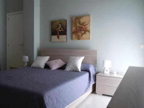 - une chambre avec un lit et 2 photos sur le mur dans l'établissement Tonnara apartment 1st floor codi facing the sea with view - wi-fi, à Avola