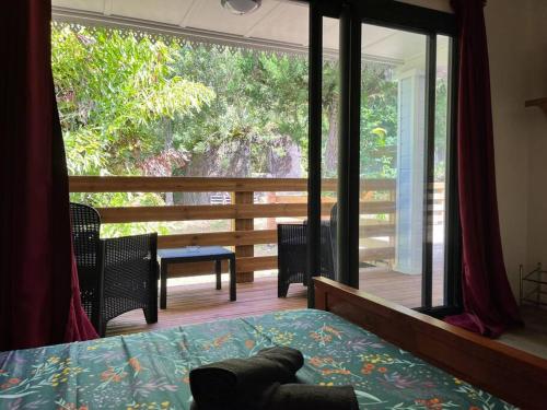 Schlafzimmer mit einem Bett und einem großen Glasfenster in der Unterkunft La Trinité, charme historique du Sud Sauvage in Saint-Philippe