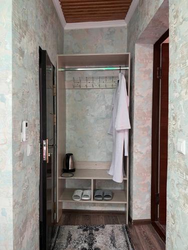 a walkin closet with a white robe and shoes at Hotel Guest House GOLDEN DEGREZ in Bukhara
