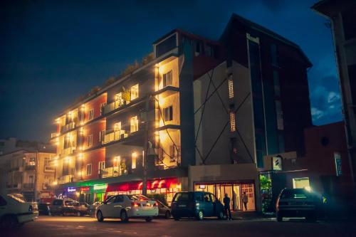 un edificio con coches aparcados delante de él por la noche en Le Grand Mellis Hôtel & Spa, en Antananarivo