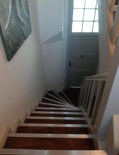 a hallway with a staircase with a window and a door at Haus mit wunderschönem Garten in Bad Freienwalde