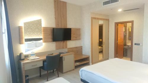 ein Hotelzimmer mit einem Schreibtisch, einem Bett und einem Schlafzimmer in der Unterkunft Isnova Hotel in Antalya