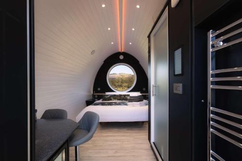 um pequeno quarto com uma cama e uma janela em Endrick Escape - Luxury Glamping 