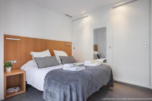 - une chambre avec un grand lit et des serviettes dans l'établissement Flateli Navas D02, à Barcelone