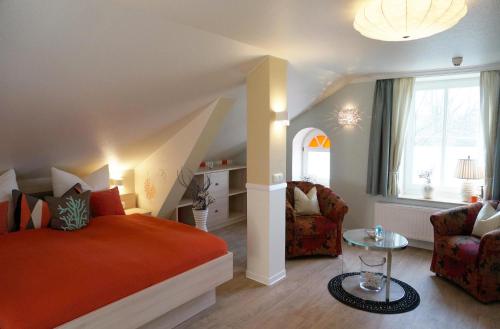 Un dormitorio con una cama y una silla y una ventana. en Apartments der "Alten Apotheke" Prerow, en Prerow