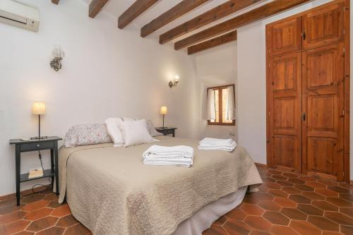 a bedroom with a bed with white towels on it at Ca'n Mayol (Banyeta) in Fornalutx