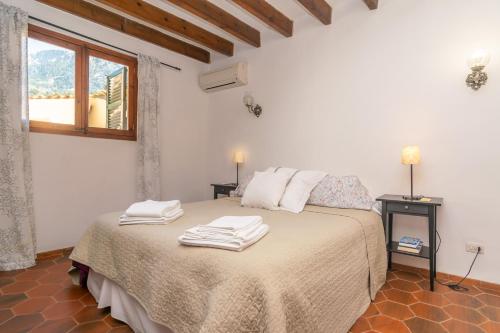 a bedroom with a bed with towels on it at Ca'n Mayol (Banyeta) in Fornalutx