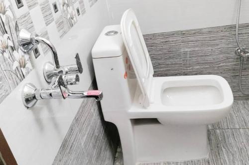 un bagno con un water bianco e un lavandino di Servostay Fully Furnished 2 BHK in Hafeezpet #102 a Hyderabad