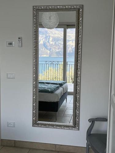 a mirror in a room with a bed and a window at MonyStelly in Cà Romana in Brenzone sul Garda