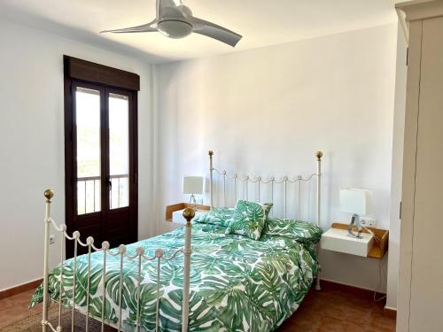 - une chambre avec un lit et un ventilateur de plafond dans l'établissement Casa Pueblo Overlooking the Village of Lubrín!, à Lubrín