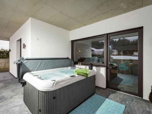 a jacuzzi tub in a room with a patio at Ledermaier Loft & Lodge`s eU in Achenkirch