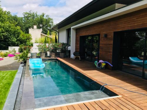 une piscine dans l'arrière-cour d'une maison dans l'établissement la villa du Lys Toulouse Occitanie Piscine & golf, à Seilh