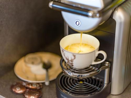 a coffee maker is making a cup of coffee at Ledermaier Loft & Lodge`s eU in Achenkirch