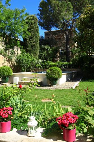 a garden with flowers in pots in the grass at La Regalido in Fontvieille
