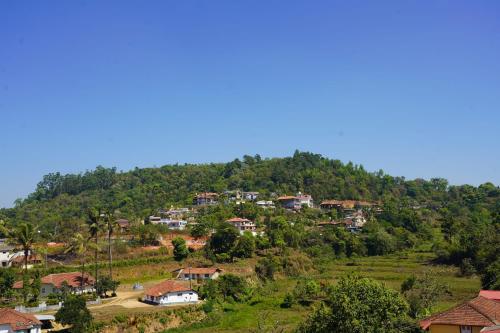 a village on the side of a hill with houses at Royal Coorg Guest house in Madikeri