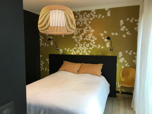 - une chambre avec un lit blanc et un lustre dans l'établissement la villa du Lys Toulouse Occitanie Piscine & golf, à Seilh
