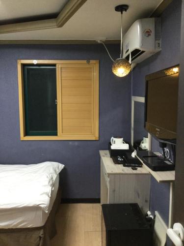 a room with a bed and a kitchen with a stove at G Mini Hotel Dongdaemun in Seoul