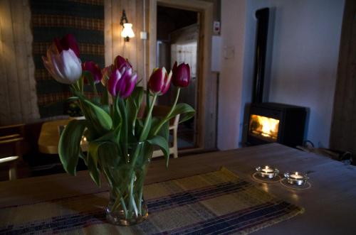 a vase of purple and white tulips on a table at Putten Seter in Høvringen