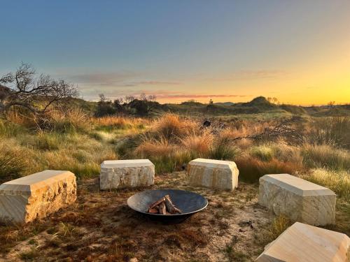 a fire pit in the middle of a field at Elements - Freycinet Holiday Houses in Dolphin Sands