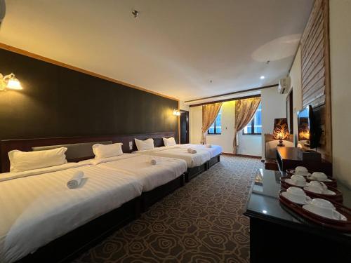 a hotel room with two beds and a television at Herald Hotel Melaka by D'Concept in Malacca