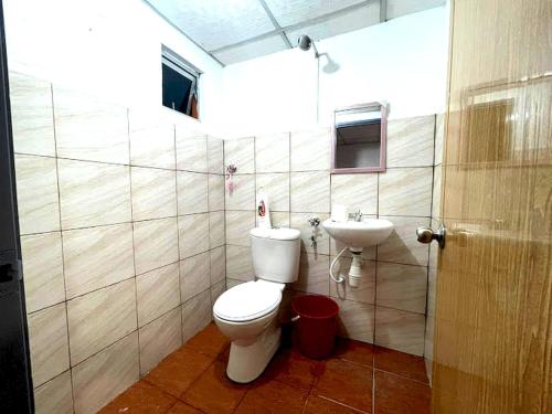 a bathroom with a toilet and a sink at OYO HOME 90768 Flo Inn Motel in Tawau