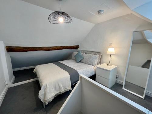 a small bedroom with a bed and a mirror at Central Cottage, Hot Tub in Shottery