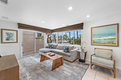 uma sala de estar com um sofá e uma mesa em Villa Lanai at the Sunset Cove Villas em Laguna Beach