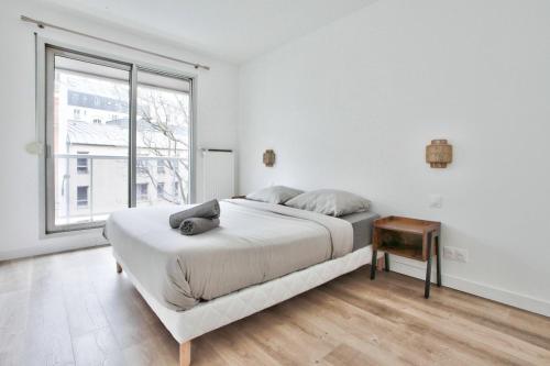 une chambre blanche avec un grand lit et une fenêtre dans l'établissement Appartement Quartier Panthéon Free Netflix, à Paris