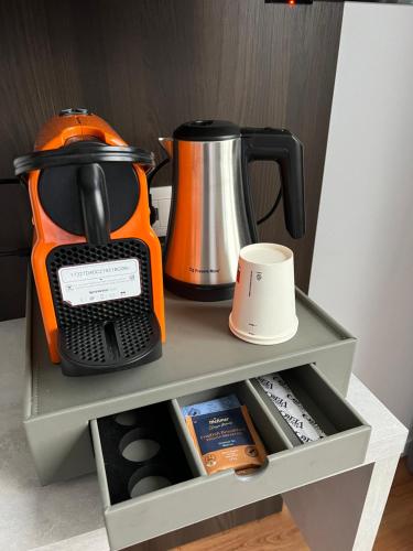 an orange coffee maker sitting on top of a shelf at Wind Hotel in Malcesine