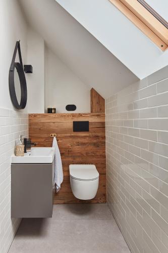 a bathroom with a white toilet and a sink at HighZen Pozezdrze in Pozezdrze
