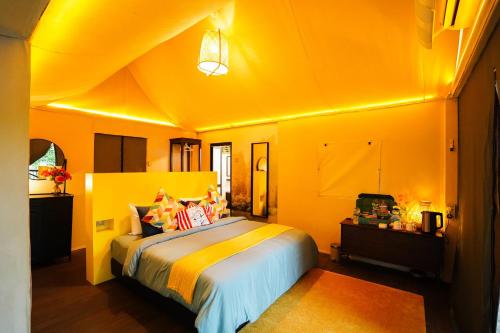 a bedroom with a large bed with yellow walls at SUNWAY LAGOON SDN BHD in Subang Jaya