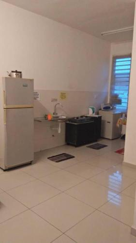 a kitchen with a refrigerator and a sink at Penang holiday villa in Jelutong
