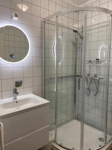 y baño con ducha y lavamanos. en Stor-Elvdal Hotell en Koppang