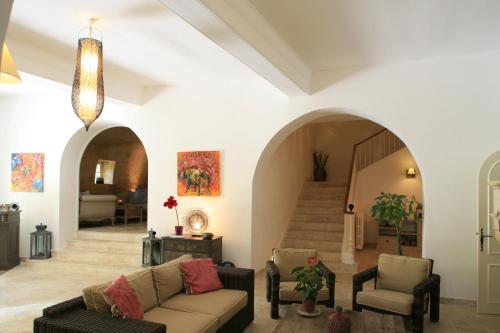 a living room with a couch and chairs and a staircase at La Regalido in Fontvieille