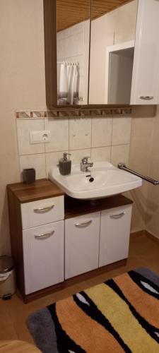 的住宿－Haus Waldblick，浴室设有水槽、镜子和地毯。