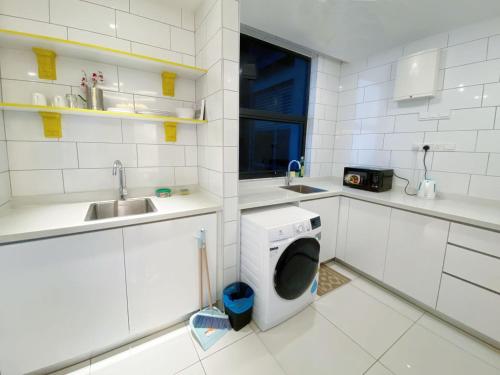 a white kitchen with a washing machine in it at Arte Mont Kiara By Awesomestay in Kuala Lumpur