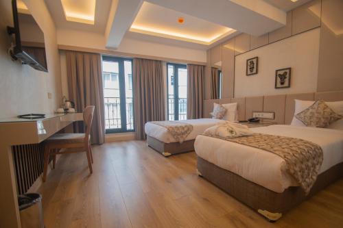 a hotel room with two beds and a desk at Vera Life Hotel in Istanbul