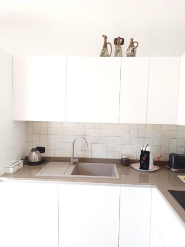 a kitchen with white cabinets and a sink at My Bellagio Home in Bellagio