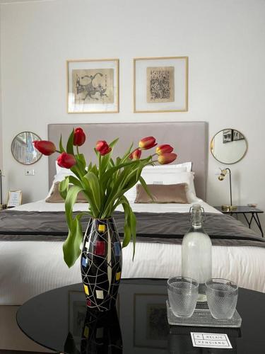 a bedroom with a bed and a vase with flowers on a table at Relais Pensiero in Verona