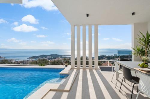 a villa with a swimming pool and a table and chairs at Luxury Villa Sagnia, 4 en-suite bedrooms, sea views in Makarska