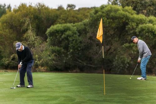 two men playing golf on a golf course at Lawson Lodge Country Estate in Macedon
