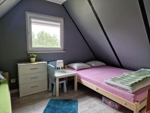 a bedroom with a bed and a desk and a window at Domek Konrad - balia ogrodowa dodatkowo płatna in Kościerzyna