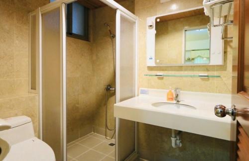 a bathroom with a sink and a shower and a toilet at 華納小筑 in Kenting