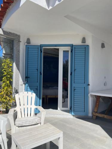 a patio with blue doors and a chair and a table at Domus de Diana in Olbia