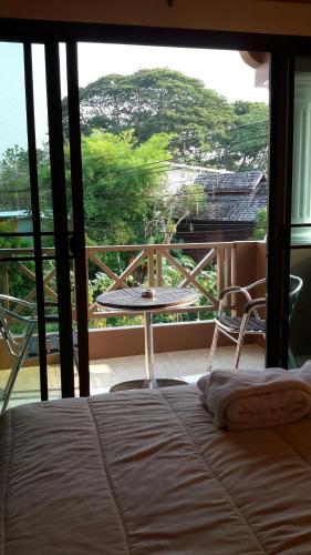 a bedroom with a bed and a table on a balcony at Donchai House Guest House& Cafe in Chiang Mai
